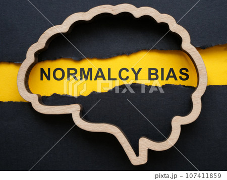 Brain outline, torn paper and sign normalcy bias. 107411859