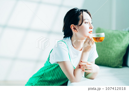 紅茶を飲む若い女性。 107412018