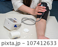 A woman measures her blood pressure. Self-medication concept. 107412633
