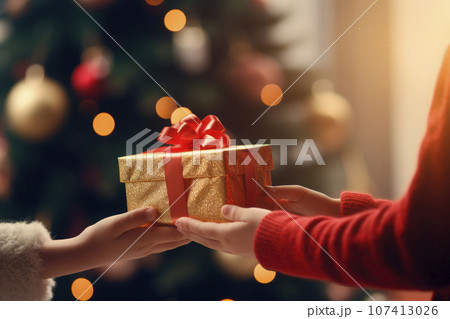 closeup detail of a girl's hands holding a gift on christmas morning 107413026