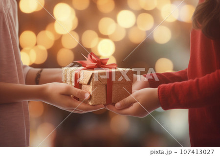 closeup detail of a girl's hands holding a gift on christmas morning closeup detail of a girl's hands holding a gift on christmas morning 107413027