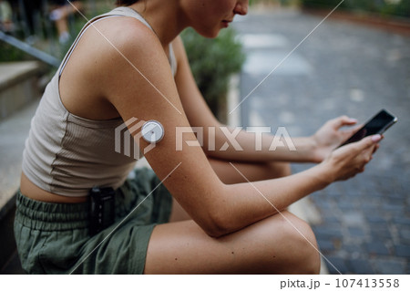 Beautiful diabetic woman preparing for outdoor workout in the city. 107413558