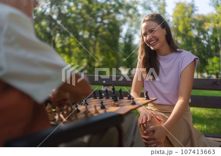 A young caregiver spending quality time with lonely senior client in the city park. 107413663