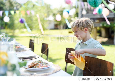 Hungry boy looking at a plate full of grilled dishes on the table. Hungry boy looking at a plate full of grilled dishes on the table. 107413704