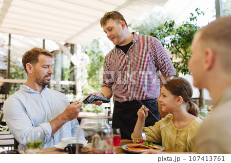 Man paying for lunch in a restaurant by card. Man paying for lunch in a restaurant by card. 107413761