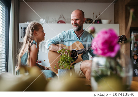 Father playing guitar for his cute daughter. Father playing guitar for his cute daughter. 107413940