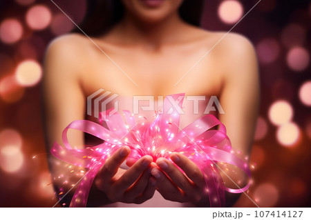 Pink ribbon in female hands close-up 107414127
