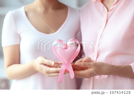 Pink ribbon in female hands 107414128