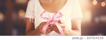 Pink ribbon in female hands 107414129