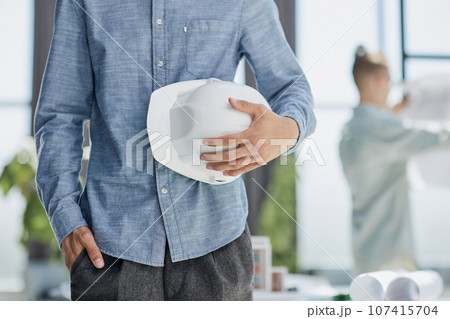Close-up of a man holding a helmet in white Close-up of a man holding a helmet in white 107415704