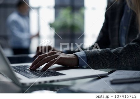 Close-up of male hands using laptop at office 107415715