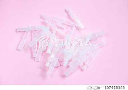 Medical eye drops in plastic pipettes. Plastic vials of saline solution 107416396