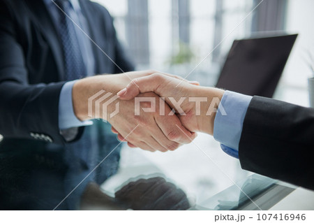 Real estate broker agent Shake hands after customer signing contract document 107416946