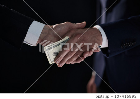 businessman hand giving money on black background businessman hand giving money on black background 107416995