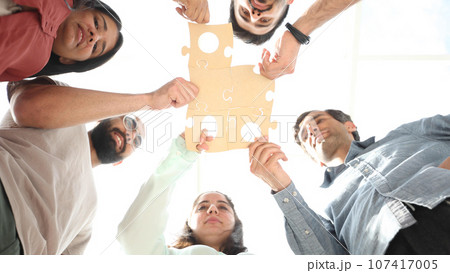 Group of business people assembling jigsaw puzzle and represent team support and help concept 107417005