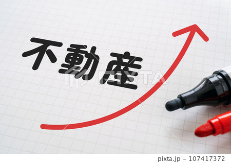 不動産と上向の矢印が書かれたノートとマーカー 107417372