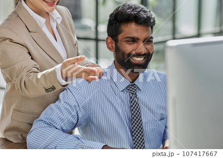 Working together on project. Two young business colleagues working on computer Working together on project. Two young business colleagues working on computer 107417667
