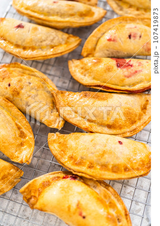Freshly baked sweet cherry empanadas in the air fryer on the kitchen counter. 107419873
