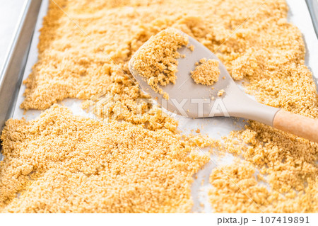 Cooling freshly dried bread crumbs on a baking sheet lined with parchment paper. 107419891