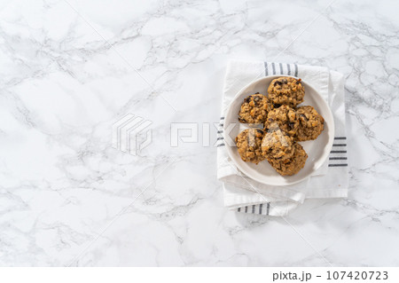 Flat lay. Freshly baked soft oatmeal raisin walnut cookies. 107420723
