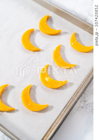 Lemon wedge cookies with lemon glaze. Rolling cookie dough with an adjustable rolling pin and cutting out cookies with cookie cutters to bake lemon wedge cookies with lemon glaze. Lemon wedge cookies with lemon glaze. Rolling cookie dough with an adjustable rolling pin and cutting out cookies with cookie cutters to bake lemon wedge cookies with lemon glaze. 107420852