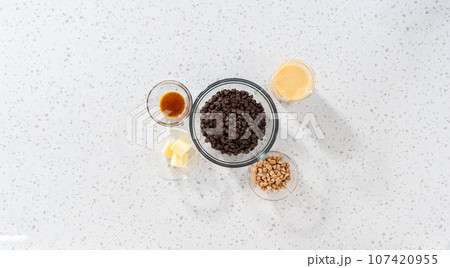 Flat lay. Measured ingredients in glass mixing bowls to make chocolate fudge with peanut butter swirl. Flat lay. Measured ingredients in glass mixing bowls to make chocolate fudge with peanut butter swirl. 107420955