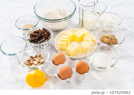 Measured ingredients in glass mixing bowls to bake mini Easter bread kulich. Measured ingredients in glass mixing bowls to bake mini Easter bread kulich. 107420982