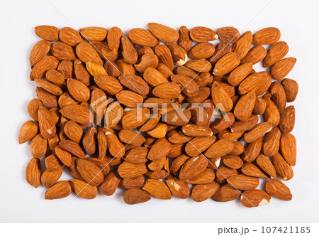 Close up of roasted almonds on white surface, no people 107421185