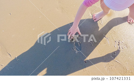 A little girl joyfully plays on the vast, empty sands of El Capitan State Beach in California during winter. A little girl joyfully plays on the vast, empty sands of El Capitan State Beach in California during winter. 107421331