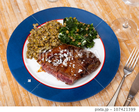 Baked beef loin with green lentils and spinach 107421399