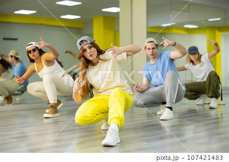 Young girl sitting in breakdance pose in dance hall 107421483