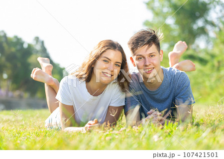 Two young people are lying on the grass Two young people are lying on the grass 107421501
