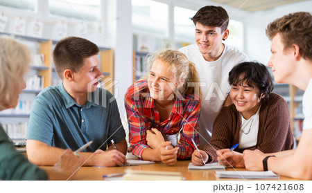 Brainstorming teen students in school library Brainstorming teen students in school library 107421608