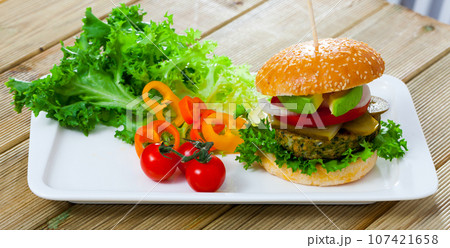 Vegetarian hamburger with soybean patty, tomato, avocado and cucumber 107421658