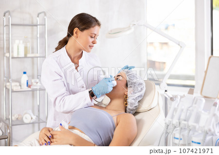 European doctor making Beauty procedure to brunette girl (vabration import) European doctor making Beauty procedure to brunette girl (vabration import) 107421971