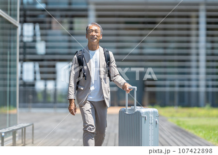 キャリーバッグを持つシニア男性 107422898