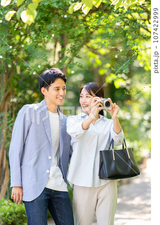 カメラを持つ笑顔の若いカップル 107422999