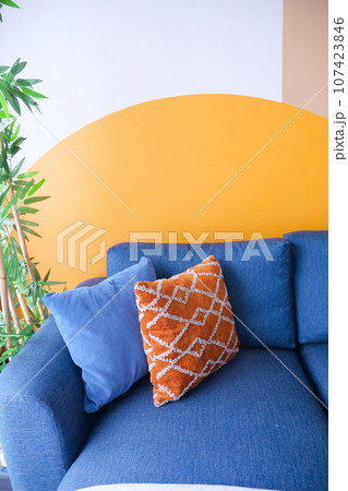 modern blue sofa with orange color pillows in living room at home 107423846