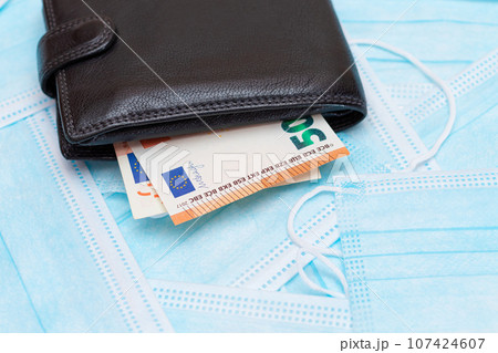 Black Men's Wallet with Euro Money Inside on the Blue Disposable Medical Face Masks Black Men's Wallet with Euro Money Inside on the Blue Disposable Medical Face Masks 107424607