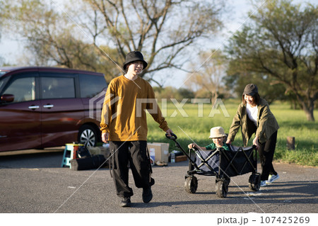 キャンプ・アウトドアカートに子供を乗せて引く家族イメージ 107425269