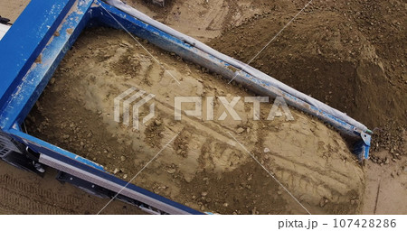 Dump truck unloading soil or sand at construction site. Dump truck unloading soil or sand at construction site. 107428286