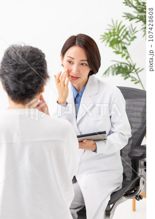 対面で問診する医者と患者 107428608