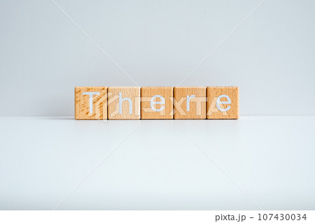 Wooden blocks form the text "There" against a white background. Wooden blocks form the text "There" against a white background. 107430034