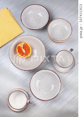 Ceramic bowls and cups are laid out on the table. 107431913