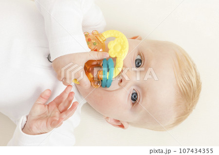 portrait of a little baby playing with a toy 107434355