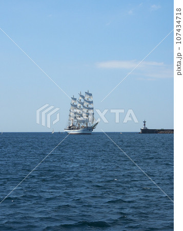 A sailing ship with white sails on three masts at sea. The concept of a cruise, vacation at sea, sailing, yachting. A sailing ship with white sails on three masts at sea. The concept of a cruise, vacation at sea, sailing, yachting. 107434718