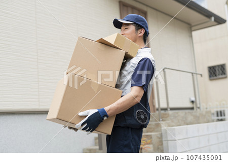 荷物を運ぶ40代配達員 荷物を運ぶ40代配達員 107435091