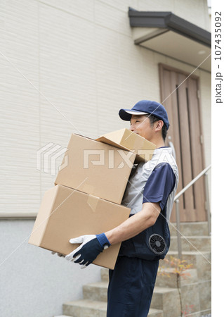 荷物を運ぶ40代配達員 荷物を運ぶ40代配達員 107435092