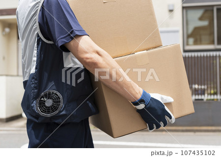 荷物を運ぶ40代配達員 107435102