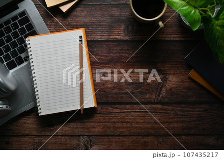 Top view of notepad, laptop computer and headphone wooden table. Space for your text 107435217